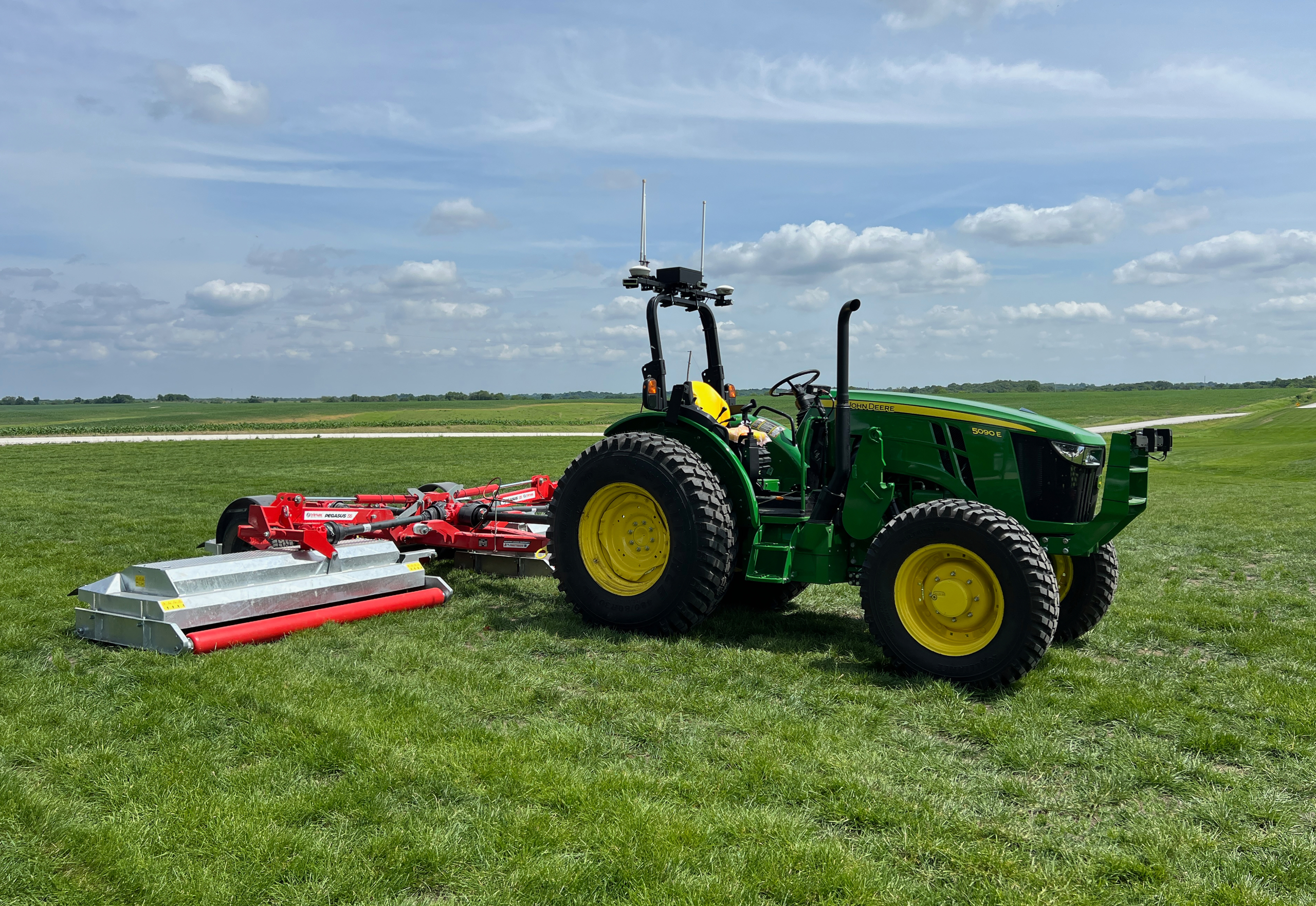 John Deere 5090E tractor fitted with the Sabanto autonomy system mowing a field